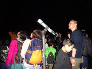 天体望遠鏡で星の様子を観測する参加者