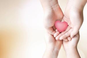 写真：ハートを包む両手とそれを支える別の両手