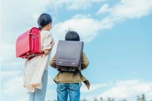 写真：ランドセルを背負った二人の小学生の背中