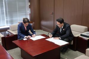 写真：株式会社八神製作所との協定書に署名している様子